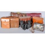 A collection of leather and crocodile skin bags along with two sets of cased binoculars