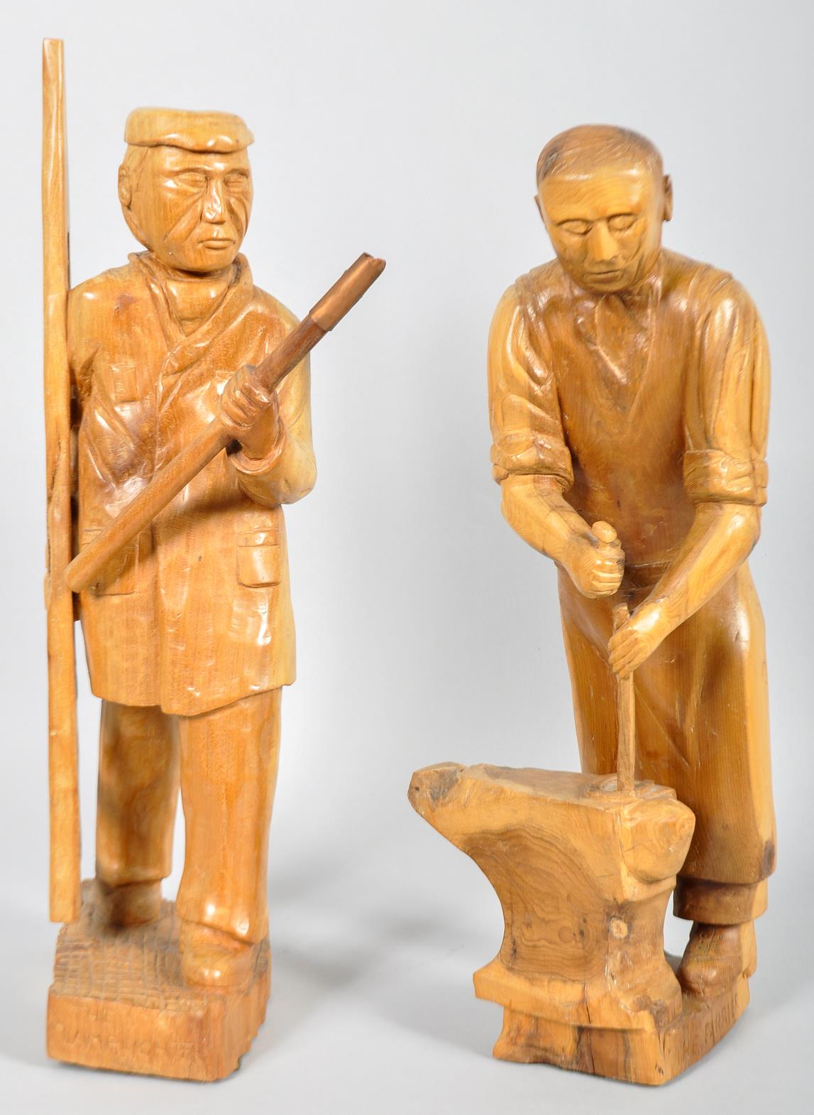 A pair of carved wooden figures depicting a 'The Lamplighter' and 'The Farrier'.