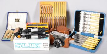 A collection of flatware and camera items