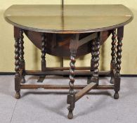 An oak barley barley twist drop leaf and gate leg dining table. Measures; 73cm x 108cm x 55cm.