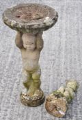 A bird bath with figure boy for support