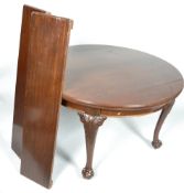 A mahogany extending dining table in the George III style, of circular form with one leaf,