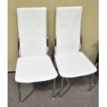 A pair of contemporary Italian dining chairs in white faux leather and raised on chromed legs.