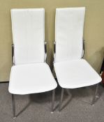 A pair of contemporary Italian dining chairs in white faux leather and raised on chromed legs.