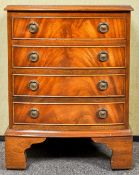 A small regency revival chest of drawers having four drawers each with loop handles,