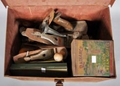 A vintage safe box tin trunk containing a collection of planes and other tools.