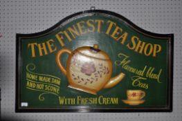 A contemporary wooden and painted sign for 'The Finest Tea Shop'. Measures; 65cm x 100cm.