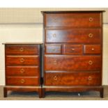 A Stag Minstrel chest of drawers having a run of seven and two bedside tables.