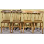 A set of four country elm dining chairs having spindle backrest,