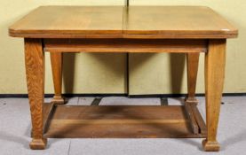 A 19th/20th Century arts and crafts oak winding extending table raised on squared shaped legs.