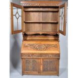 A late Victorian carved oak bureau bookcase, the upper return with twin glazed doors,