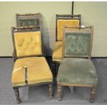 A set of four Victorian oak carved dining chairs having button backed upholstery, two in green,