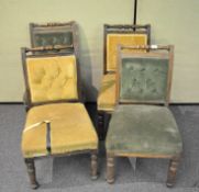 A set of four Victorian oak carved dining chairs having button backed upholstery, two in green,