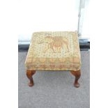 A foot stool with elephant tapesty