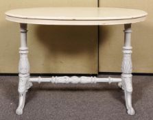 A painted oval centre table on turned supports and splayed legs. Measures; 69cm x 104cm x 58cm.