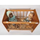 A dolls cradle and two dolls