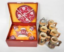 A cased Chinese porcelain tea set and a group of steins