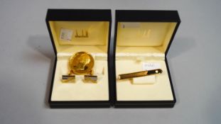 A Dunhill gold plated tie bar and a pair of cufflinks,