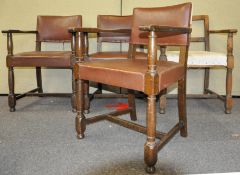 A set of four oak elbow dining chairs, having rexin studded upholstered seats,