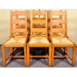 A set of six contemporary oak ladderback dining chairs with rush drop in seats, 106cm high.