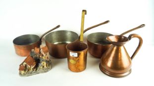 A group of copper cookware and a David Winter house