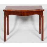 A George III mahogany folding card table, of serpentine outline,