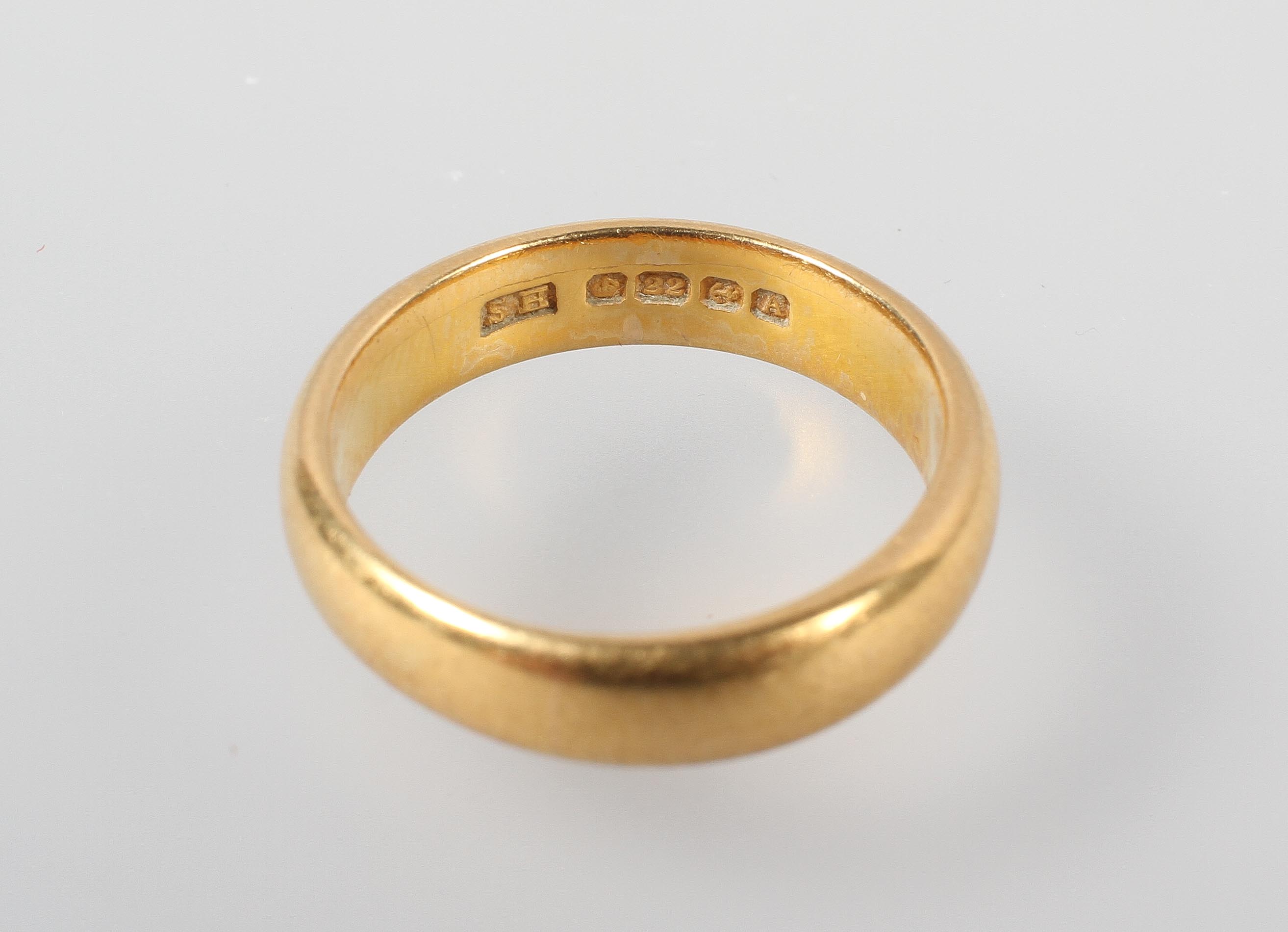 A yellow metal 4.5mm court shaped wedding ring. Hallmarked 22ct gold, Birmingham, 1925. Size: M 7. - Image 3 of 3