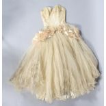 A 1950's cream silk ball gown, with cream netting and pink netting detail around the waist,