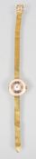 A yellow gold wristwatch. Mechanical movement. Circular with dial with numerical markings.