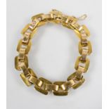 A yellow metal hollow linked bracelet with push in clasp and fitted safety chain.