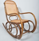 An early 20th Century Thonet style Czech bentwood rocker armchair having canework backrest and seat