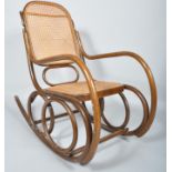 An early 20th Century Thonet style Czech bentwood rocker armchair having canework backrest and seat