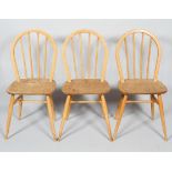 Three Ercol pale beech and elm stick back kitchen chairs, with hoop backs, on turned splayed legs,