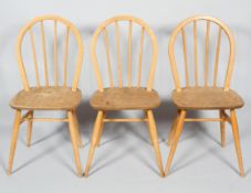 Three Ercol pale beech and elm stick back kitchen chairs, with hoop backs, on turned splayed legs,