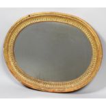 A carved giltwood oval mirror frame with recessed gadrooned frame,