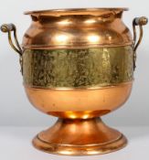 An Edwardian copper and brass two handled footed waste paper bin, of oviform shape,