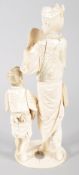 An early 20th century ivory Japanese Okimono of a father and child, the father holding a Noh mask,