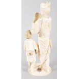 An early 20th century ivory Japanese Okimono of a father and child, the father holding a Noh mask,