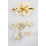 A collection of two brooches to include: A yellow metal mourning brooch stylized as a flower bow