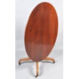 A 19th century mahogany oval tilt top table, on turned pedestal and splayed legs with brass casters,