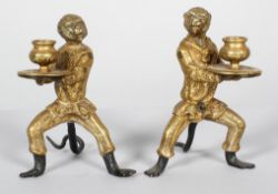 A pair of late Victorian gilt brass monkey candlesticks,