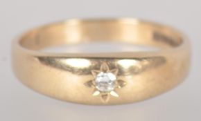 A yellow metal single stone ring.