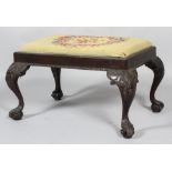 A Victorian George II style carved wood footstool, with floral tapestry seat above gadrooned apron,