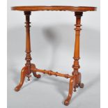A mahogany oval side table, the waved frame above turned baluster twin supports,