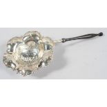 A Dutch style silver and turned wood tea strainer, of lobed hexagonal form,