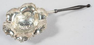 A Dutch style silver and turned wood tea strainer, of lobed hexagonal form,