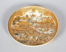 A Japanese satsuma circular dish, Meiji era (1868-1912), gilt and iron red Shimazu family crest,