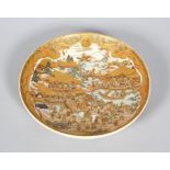 A Japanese satsuma circular dish, Meiji era (1868-1912), gilt and iron red Shimazu family crest,