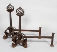 A large pair of steel fire dogs, with pierced spiral ball finials,