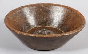 A 19th century carved oak bowl, inset silver mount with turquoise centre, probably Nepal,